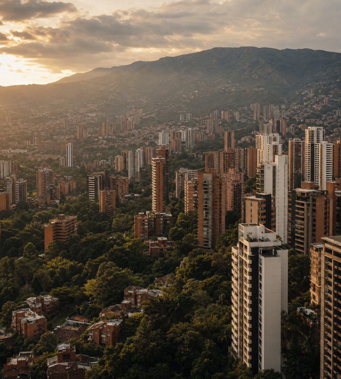 Aerial view of El Poblado, Medellín, Colombia at golden hour — modern residential high-rises framed by the Andes mountains